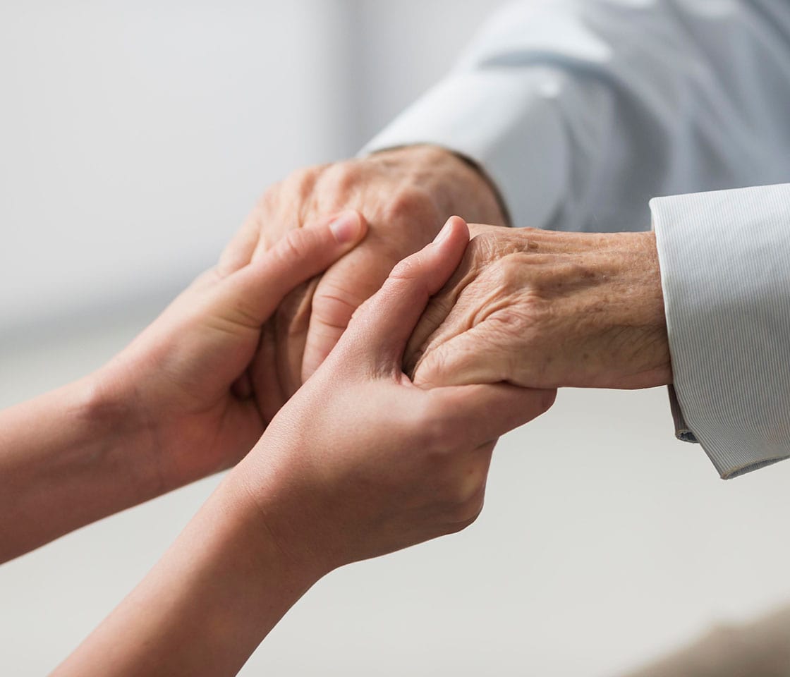 A business seller in Canada holding hands of an older man