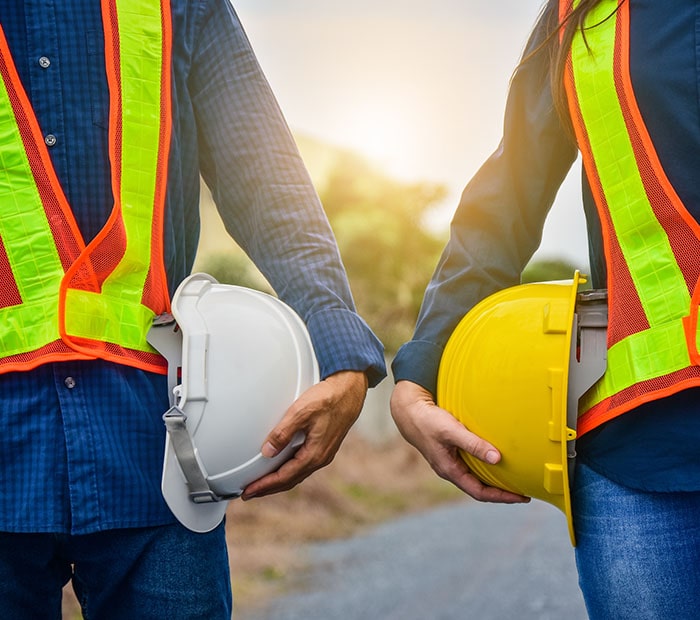 Two individuals in hard hats and safety vests, possibly discussing a business for sale in Calgary.